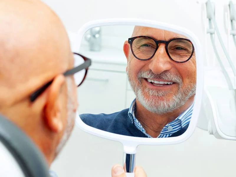Patient smiling into a mirror